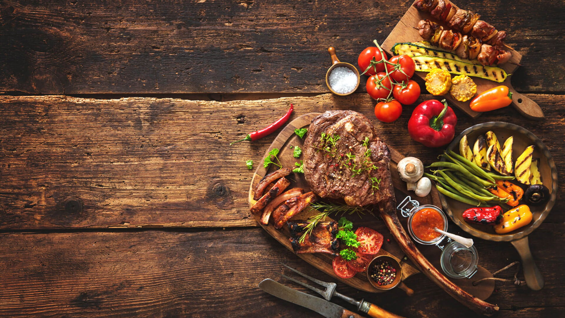 Gegrilltes Fleisch und Gemüse auf rustikalem Holztisch